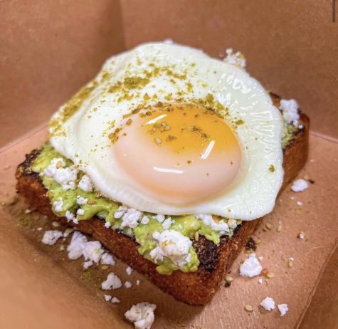Israeli Avocado Toast topped with feta cheese and a sunny side up egg (via @eatatmuriels/Instagram)